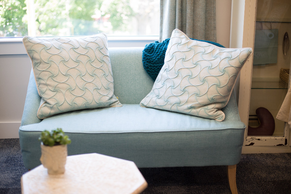 Helles Sofa mit Kissen in einem neu eingerichteten Zimmer